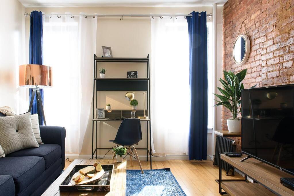a living room with a couch and a brick wall at 428-4R prime midtown large 2 BR Newly Furnished in New York