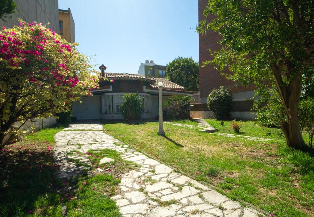 um passadiço de pedra em frente a uma casa com flores cor-de-rosa em Residencia Morón em Morón