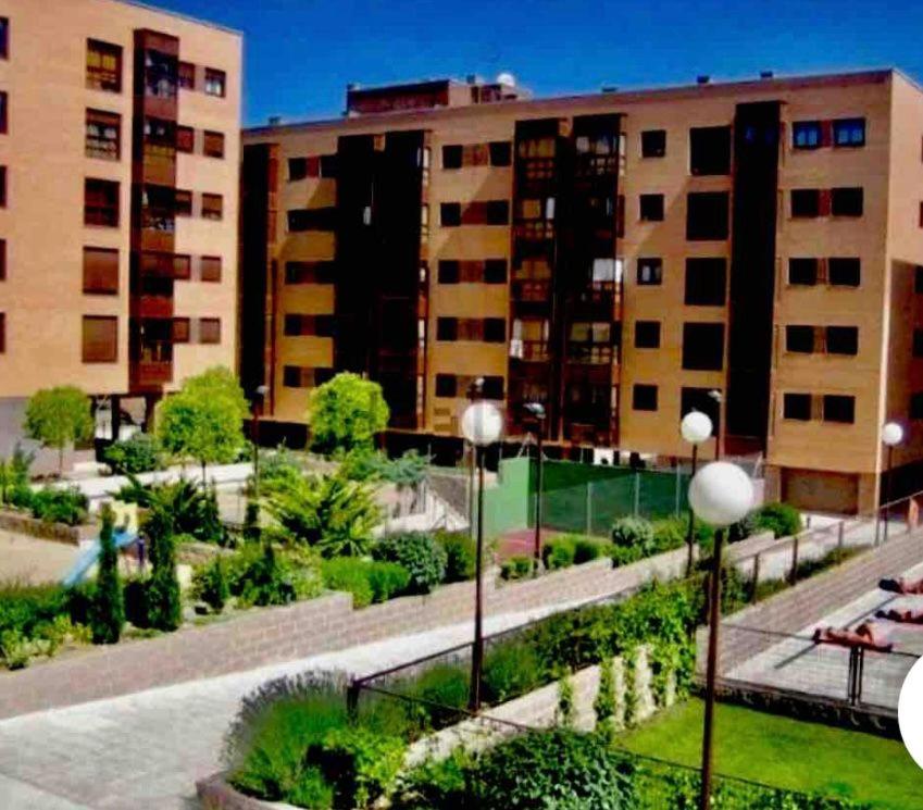 um parque em frente a dois grandes edifícios em Adolfo Suárez Madrid apartments em Madrid