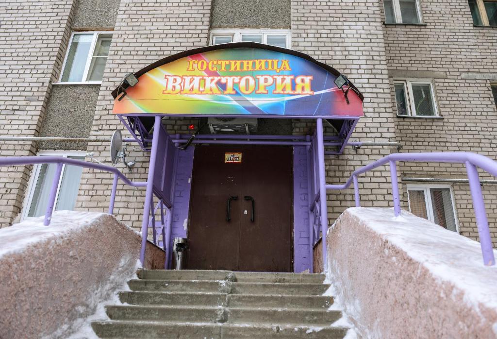 a entrance to a building with a sign on it at Viktoria Hotel in Cherepovets