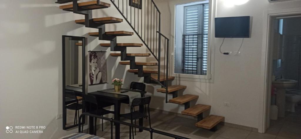 spiralne schody w salonie ze stołem w obiekcie Porta Merlonia house w Forli