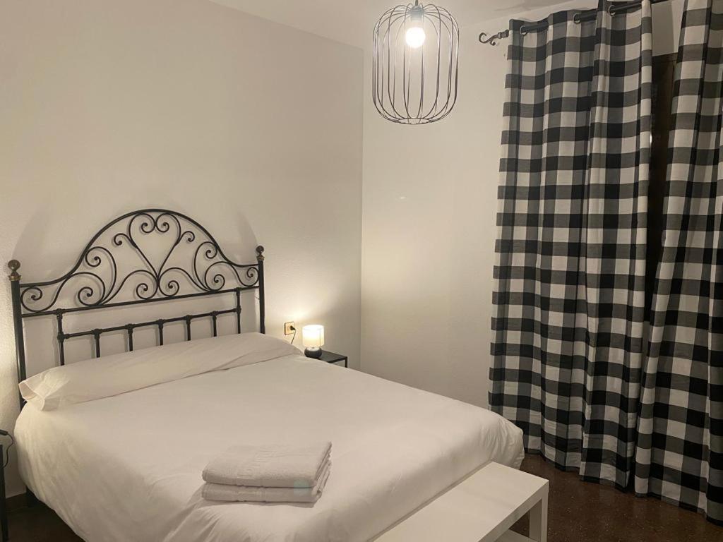 a bedroom with a bed with a black and white curtain at Casa SanJuan in Baeza