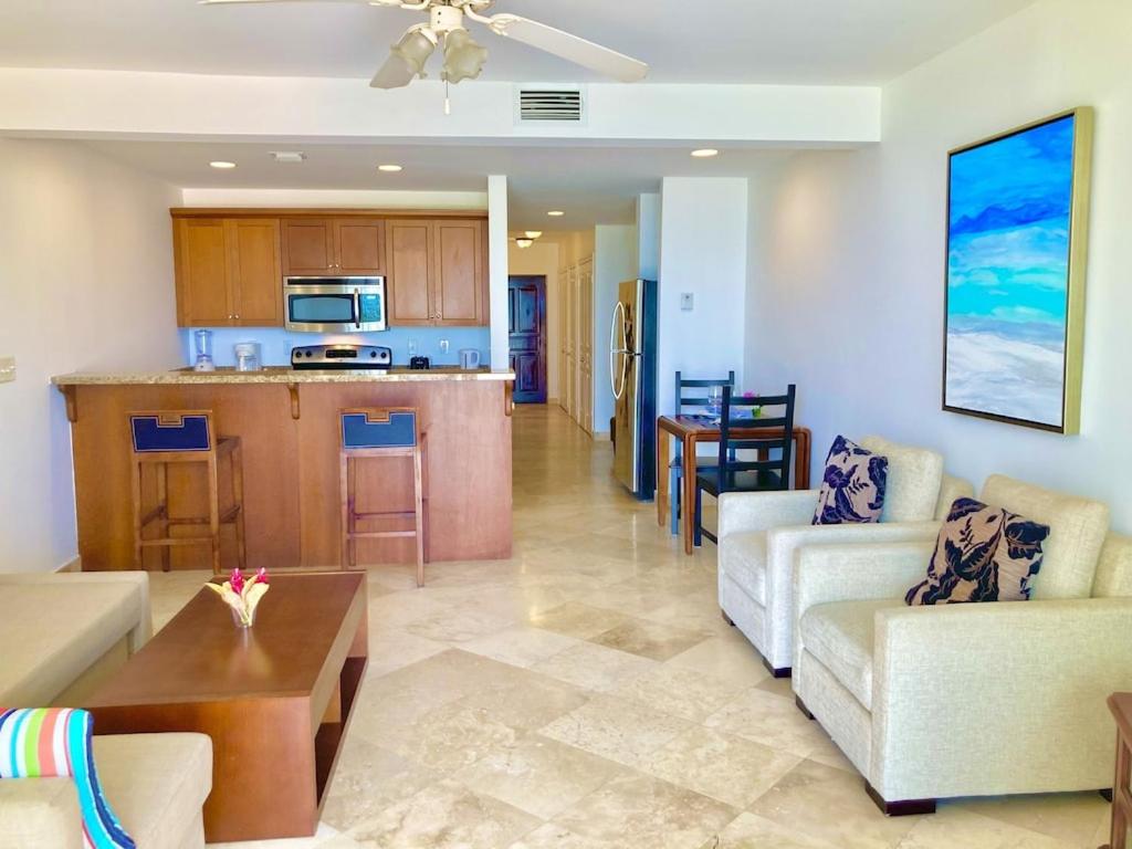 a living room with a couch and a table and a kitchen at New Listing La Vista Azul Spacious 1 Bedroom Condo in Turtle Cove
