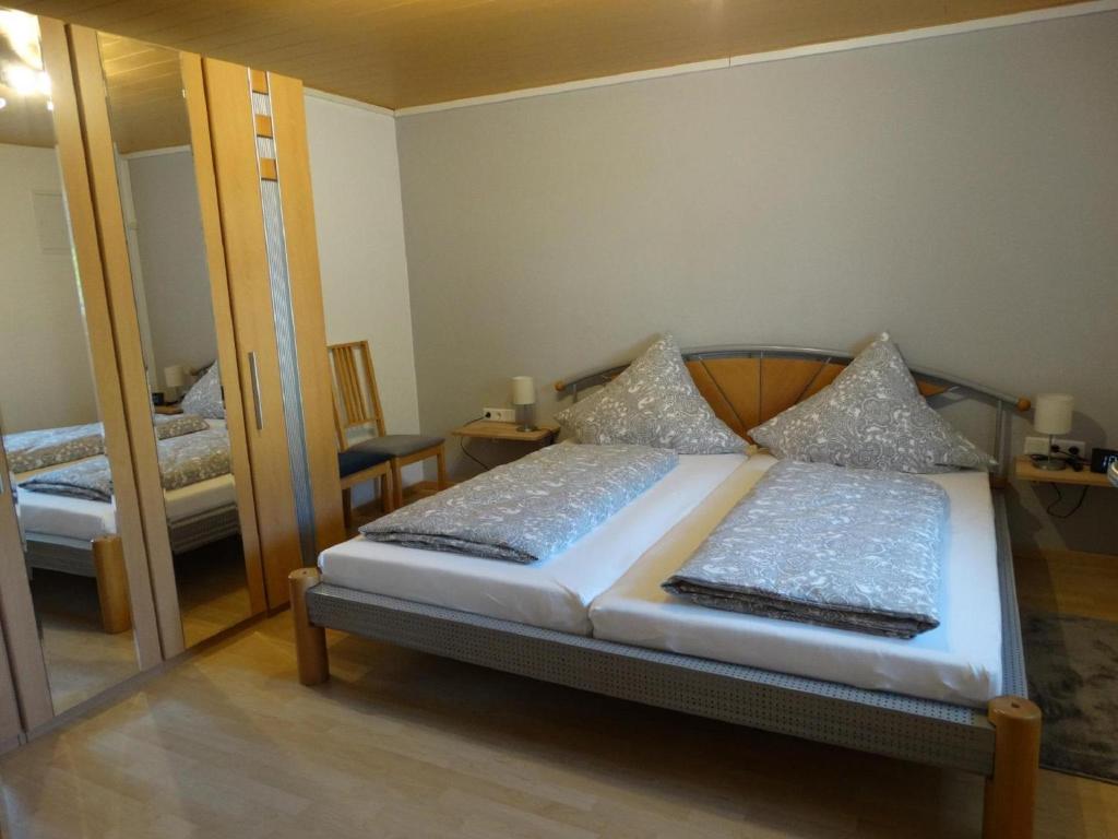 - une chambre avec un lit et un grand miroir dans l'établissement Ferienwohnung Christine, à Heckendalheim