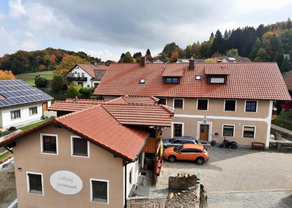 un coche naranja estacionado frente a una casa en Lukashof, en Waldmünchen
