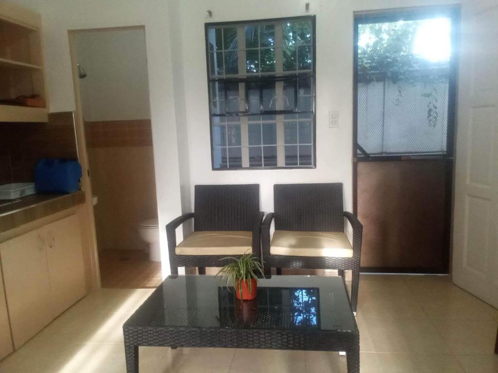 卡加延德奧羅的住宿－Kendall Place Apartment，客厅配有两把椅子和一张桌子