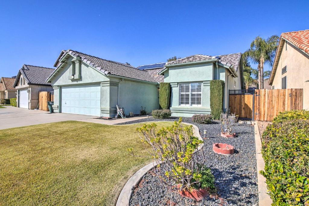 a house with a fence and a yard at Family-Friendly Getaway Community Amenities! in Bakersfield