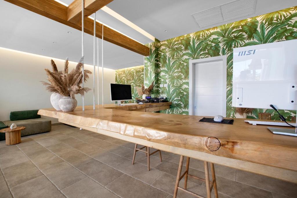 a dining room with a wooden table and a tv at Maya Beach Resort in Massa Lubrense