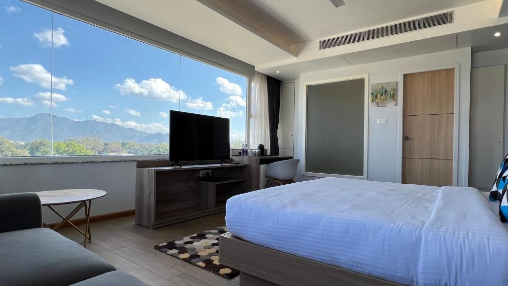sypialnia z łóżkiem i dużym oknem w obiekcie Aurora Boutique Hotel Imphal w mieście Imphal