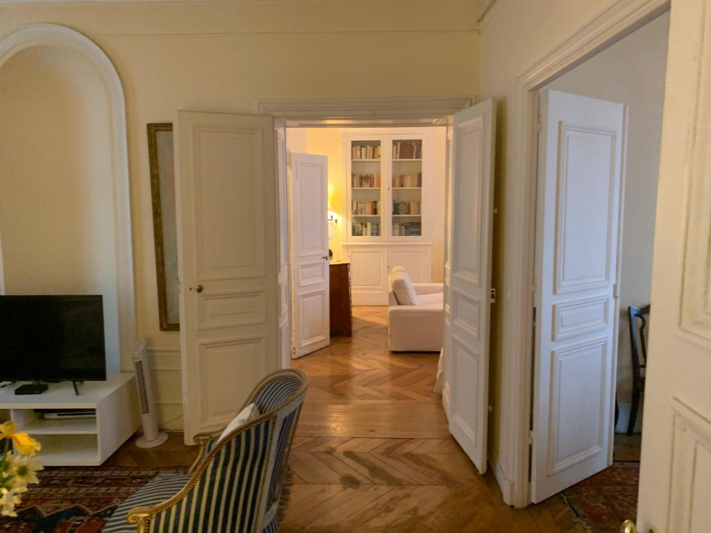 a living room with two chairs and a television at Appartement Artois in Paris