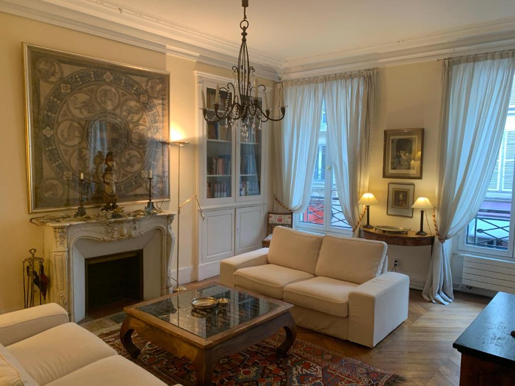 a living room with a couch and a fireplace at Appartement Artois in Paris