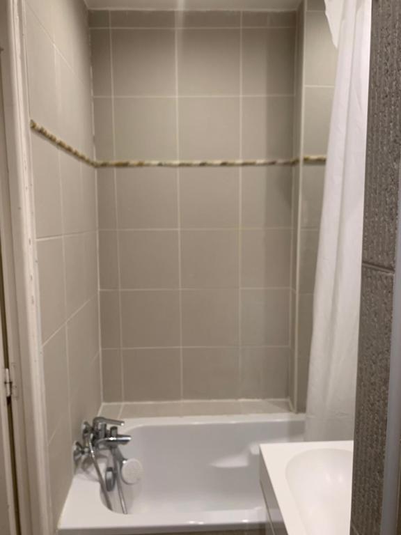 a bathroom with a white tub and a sink at Appartement Artois in Paris