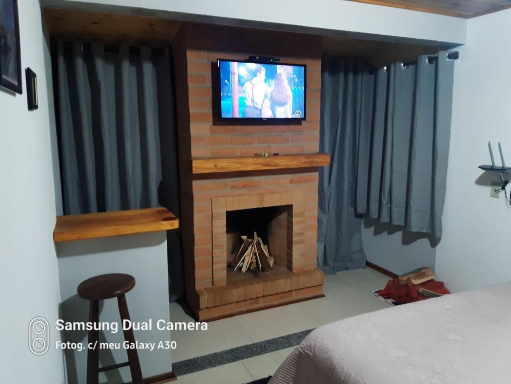 Zimmer mit Kamin und TV in der Unterkunft Casa Souza in Camanducaia