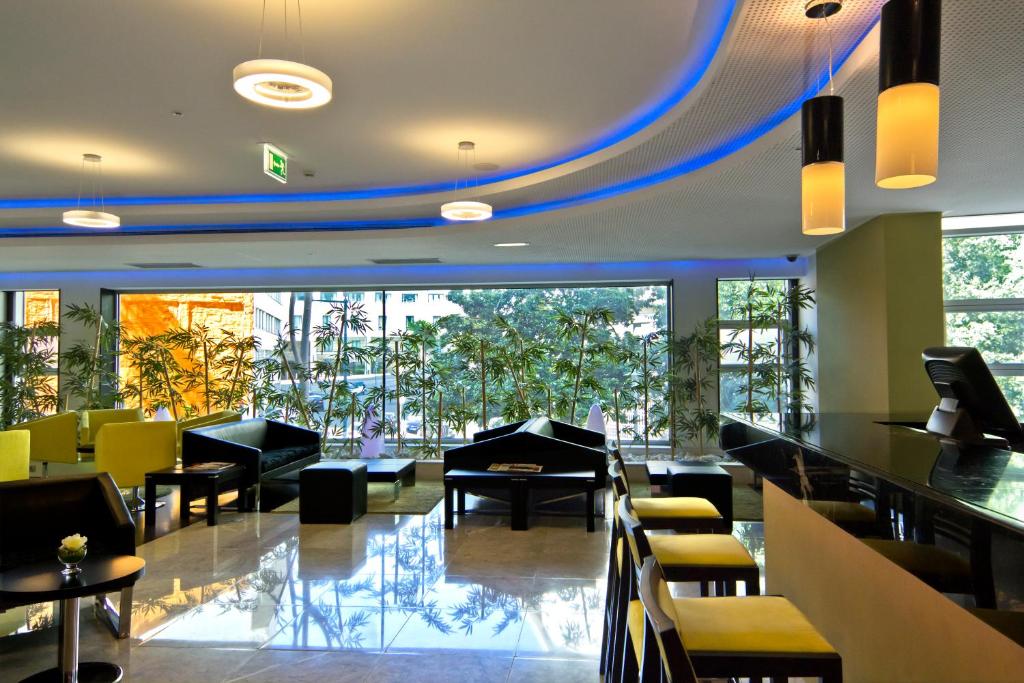 a restaurant with a lobby with tables and chairs at SANA Capitol Hotel in Lisbon