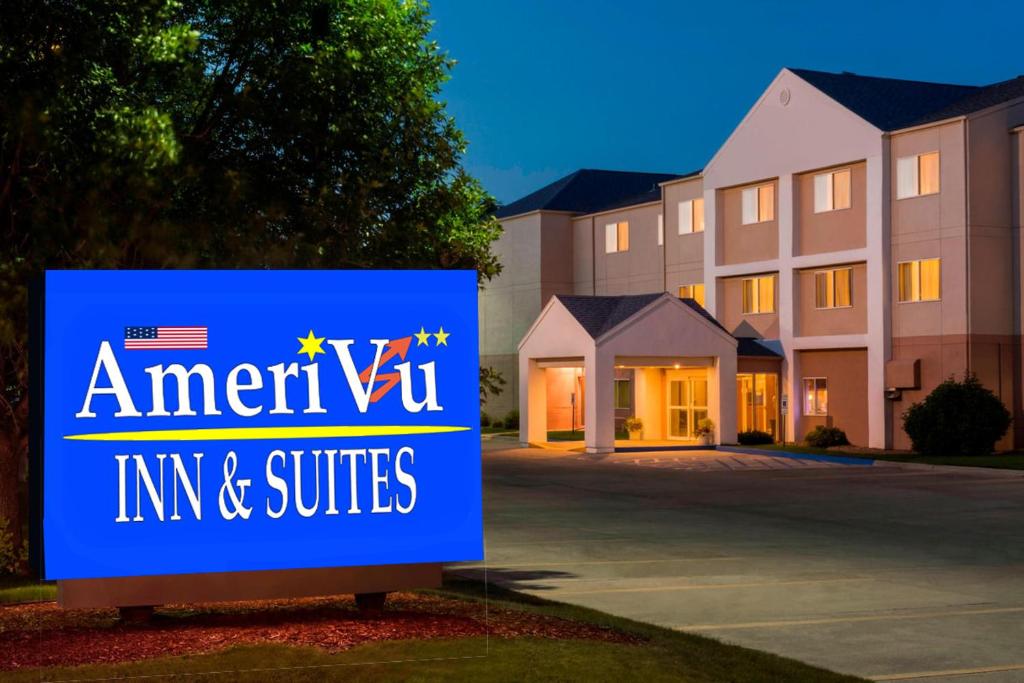 una señal para una posada y suites frente a un edificio en Amerivu Inn and Suites, en Grand Forks