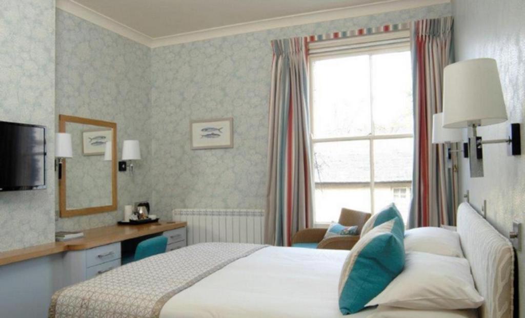 a hotel room with a bed and a window at Wentworth Hotel in Aldeburgh