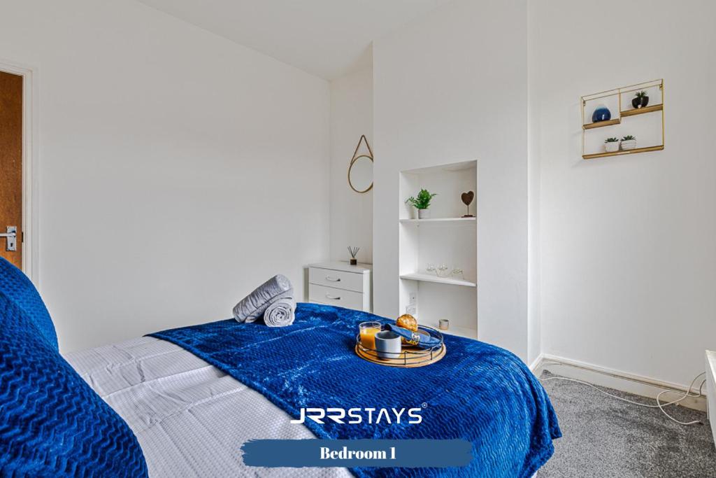 una camera da letto con una coperta blu su un letto di Stoke On Trent - 2 Bedroom Sleeps 5, Wi-Fi, Garden - JRR Stays a Etruria