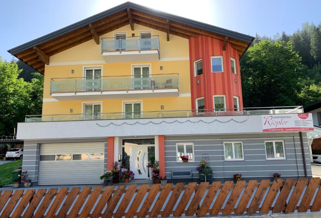 uma casa com uma cerca de madeira em frente em Appartementhaus Riepler em Bad Gastein