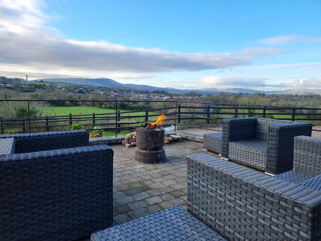 a fire pit with couches and a fireplace with a view at Captivating & Cosy 4-Bedroom House in Magherafelt in Magherafelt