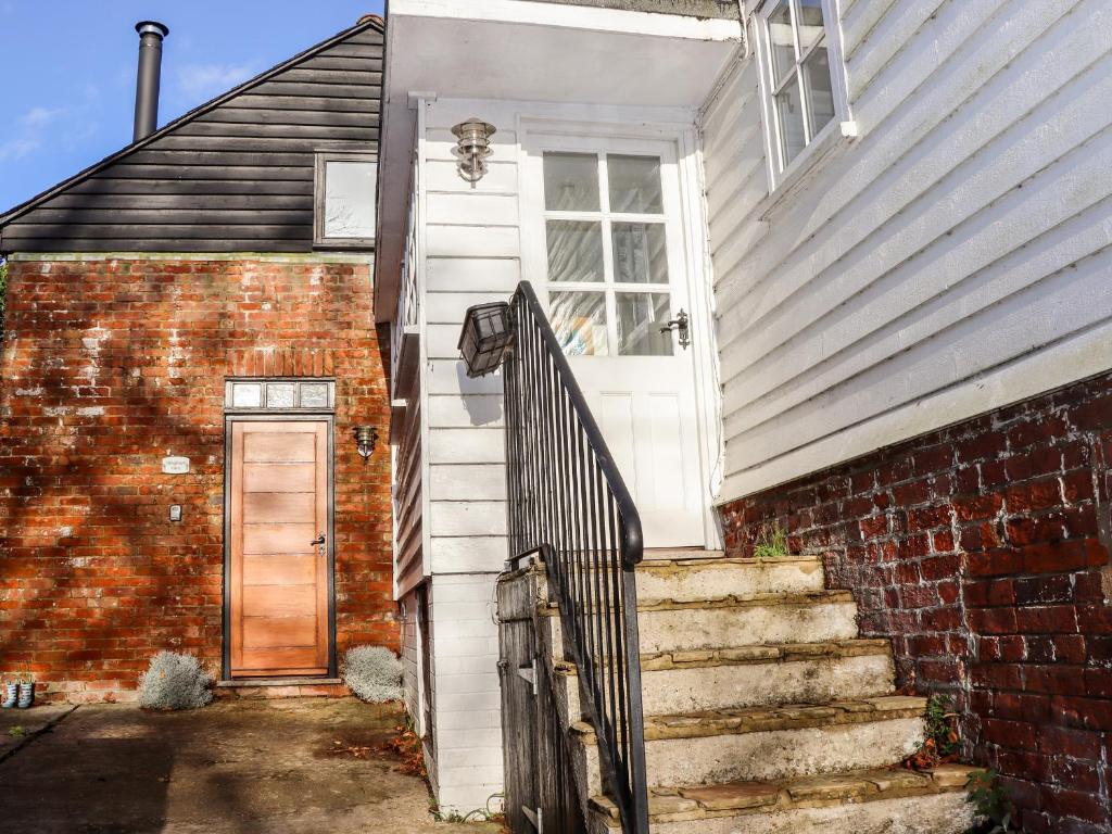 an old brick house with a door and stairs at Tillingham View in Rye