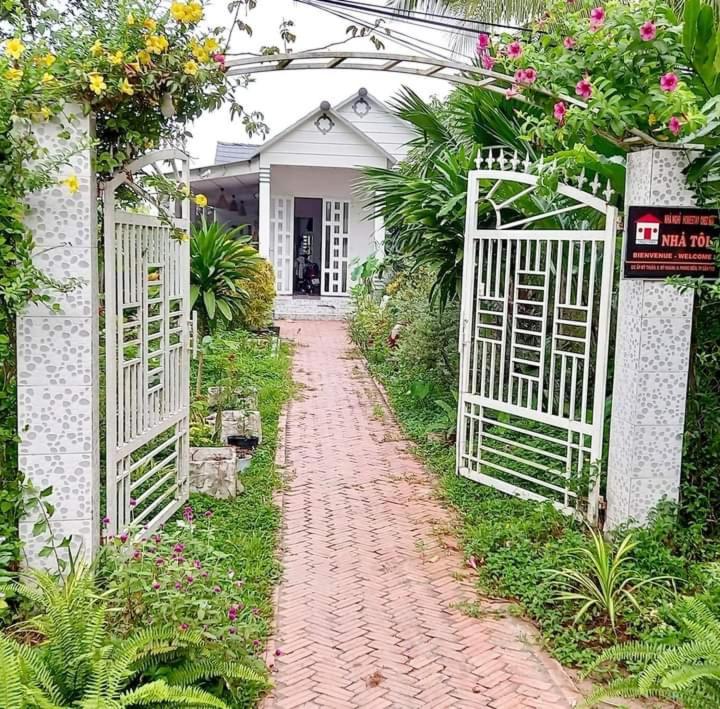 a brick path in front of a house with a white gate at Homestay Chez Moi in Can Tho