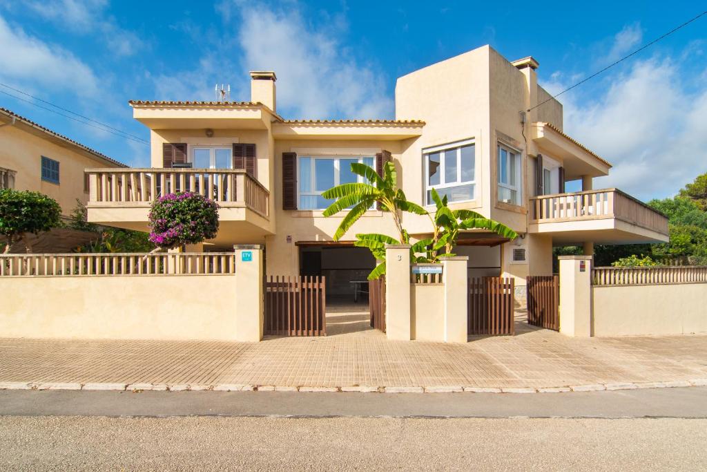 una casa en una calle con una valla en ES GANXO HOUSE PORTO CRISTO en Porto Cristo