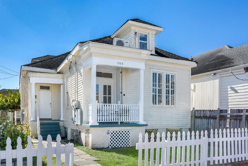 a white house with a white picket fence at Uptown Spacious 4BD/3BA with Historic Charm in New Orleans