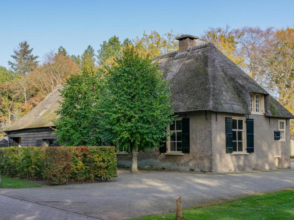 una antigua casa de piedra con techo de paja en De Jager en de gelagkamers en Gouwelaar