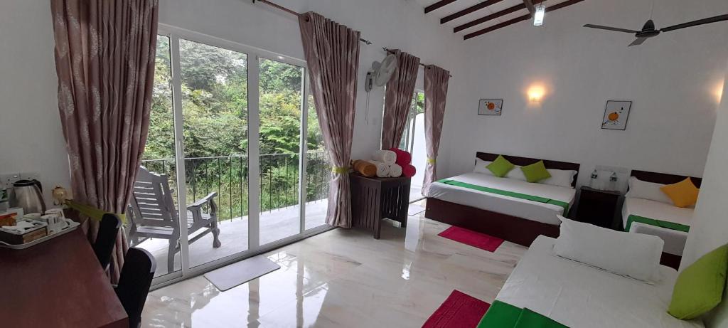 een woonkamer met een bed en een groot raam bij Senomaal Sigiri Resort in Dambulla