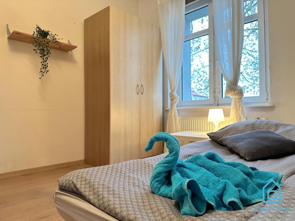 a blue towel on a bed in a bedroom at Beige Room in Gdańsk
