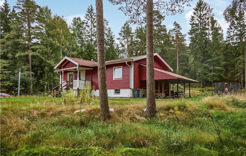 uma casa vermelha num campo com árvores em Amazing Home In Henn With Kitchen em Henån