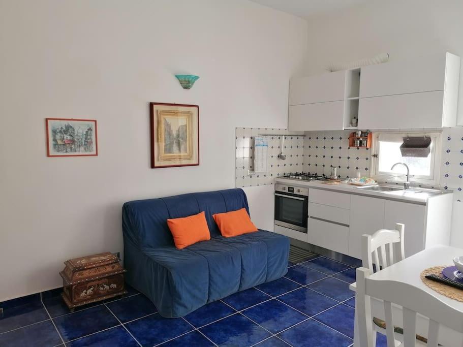 uma sala de estar com um sofá azul numa cozinha em Grazioso appartamento a Ischia zona pilastri em Ischia