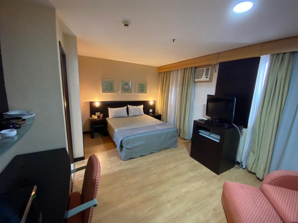 pokój hotelowy z łóżkiem i telewizorem w obiekcie Flat na Vila Olimpia rua Santa Justina w São Paulo