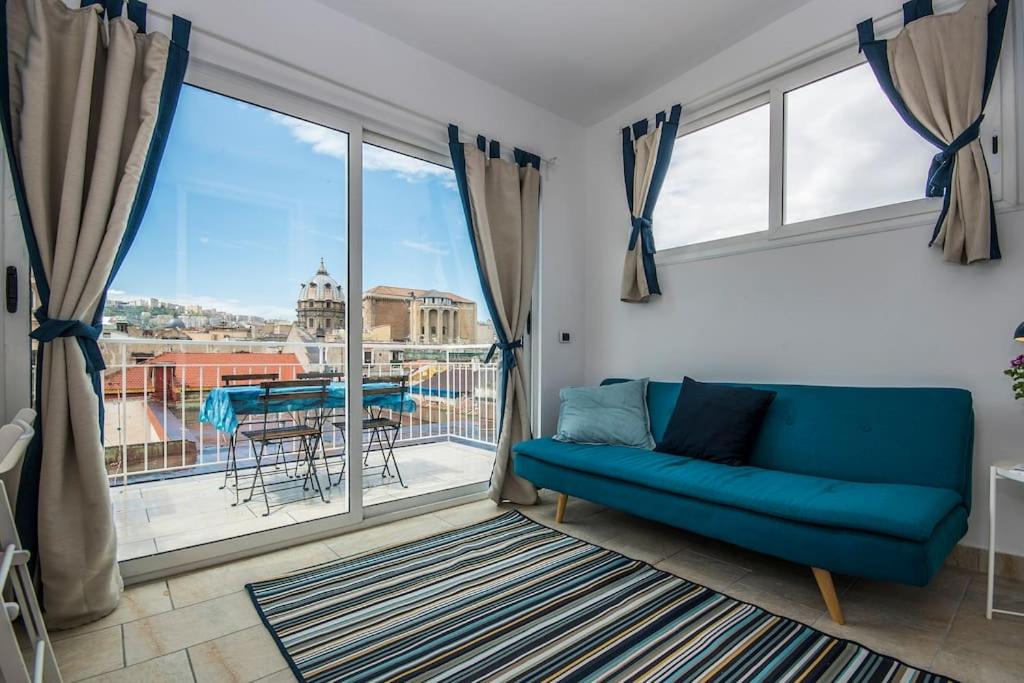 - un salon avec un canapé bleu et une grande fenêtre dans l'établissement View of Naples from terrace- 6, à Naples