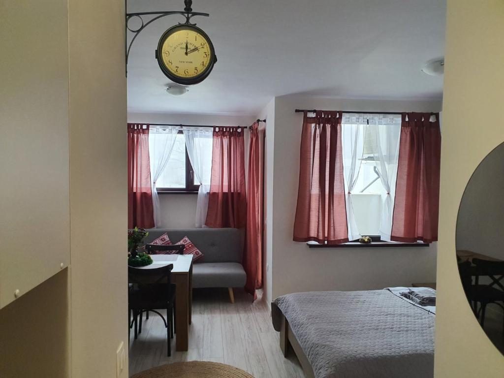 a room with a bed and a clock on the wall at Апартамент B9 in Borovets