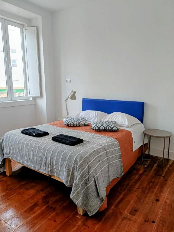 Un dormitorio con una cama grande con cabecero azul. en Casa Vale Apartments, en Lisboa
