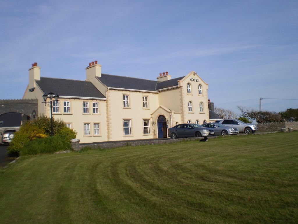 uma casa grande com carros estacionados em frente em Aran View Country House em Doolin