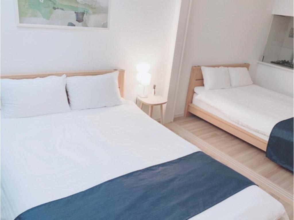 a bedroom with two beds and a small table at ＥＵＲＯＰＥＡＮ ＨＯＵＳＥ ＲＥＩＳＥＮ - Vacation STAY 10517v in Fukuoka