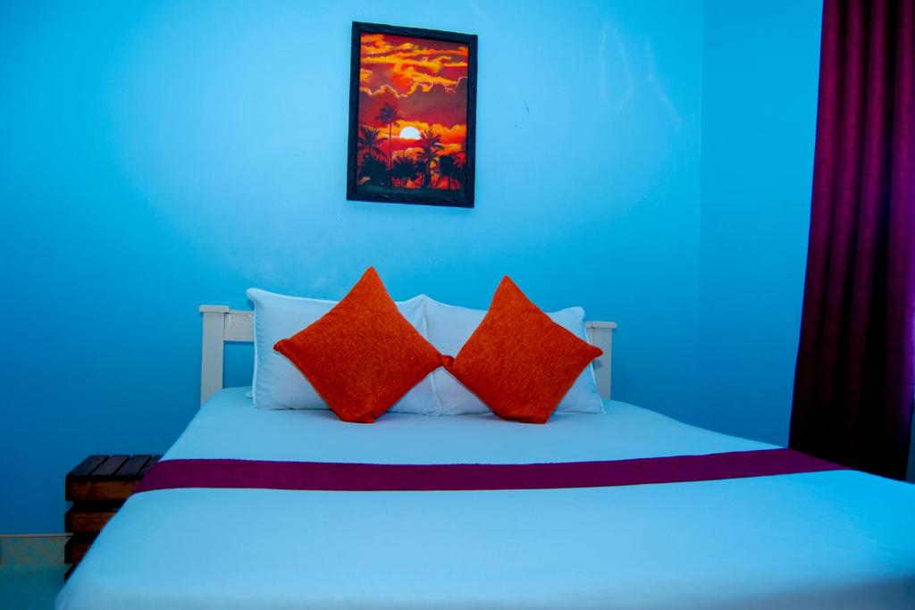 a bedroom with a bed with red pillows at Magnolia Cosy 1 Bedroom Apartment-KILIFI in Kilifi