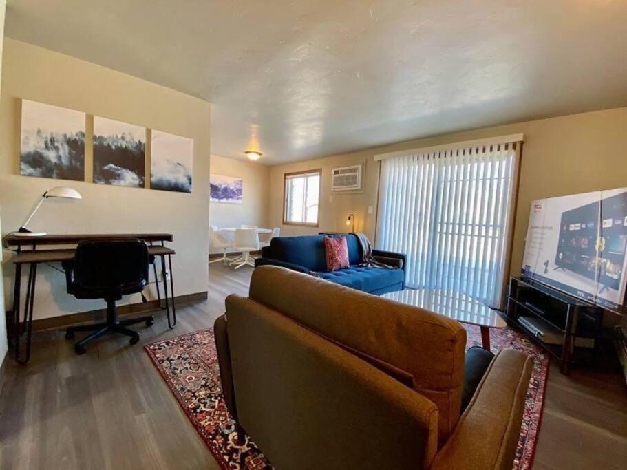 ein Wohnzimmer mit einem Sofa, einem Tisch und einem TV in der Unterkunft Conveniently located two-bedroom apartment in Green Bay