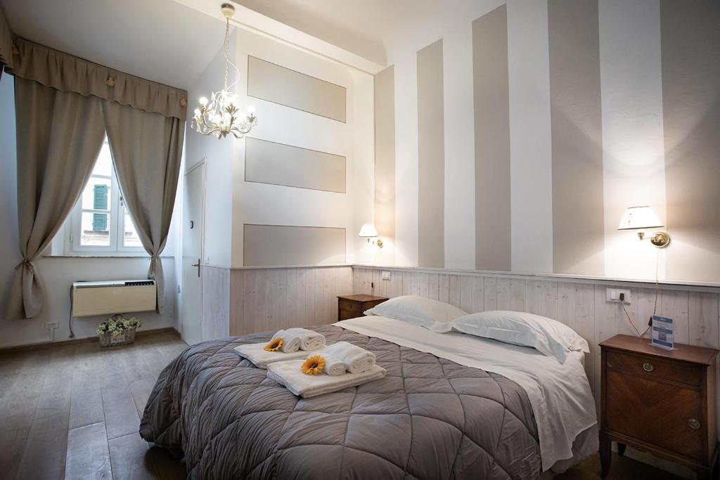 a bedroom with a large bed with towels on it at Residenza Centro Storico in Lucca