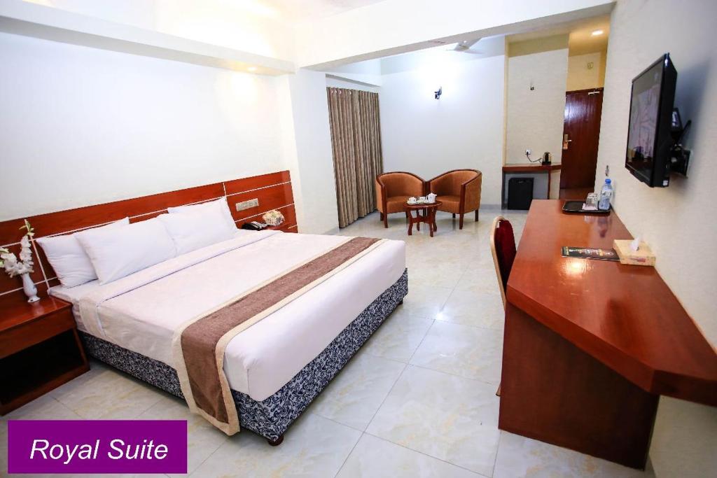 Royal Beach Resort في كوكس بازار: غرفة في الفندق مع سرير مزدوج كبير ومكتب