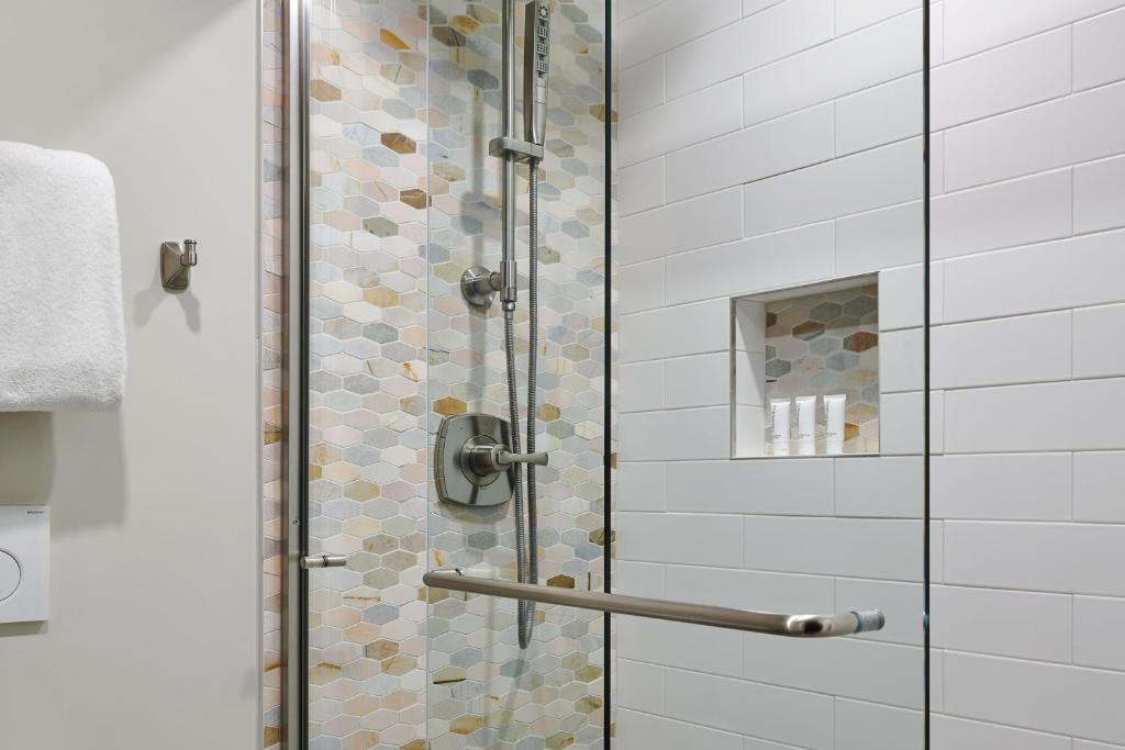 a shower with a glass door in a bathroom at The Inn at Aspen in Aspen