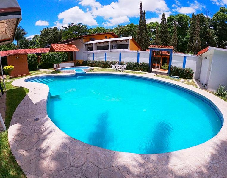 a large blue swimming pool in front of a house at Casa Kolping in Tuxtla Gutiérrez