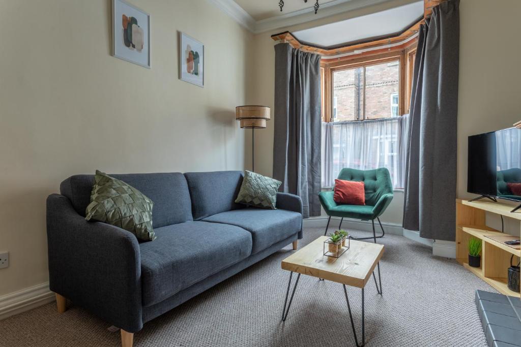 a living room with a blue couch and a tv at Milton Stays - Cosy Home in Central York for 6 With On Street Parking in York