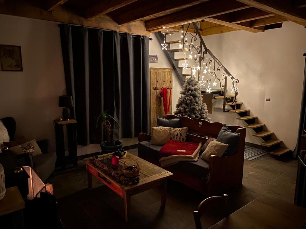 a living room with a christmas tree and a couch at L'instant présent in Echallon