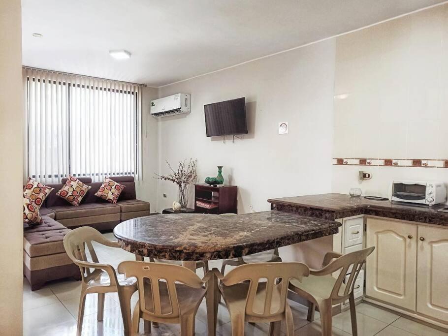 cocina y sala de estar con mesa y sillas en La Casa de la Playa, en Atacames
