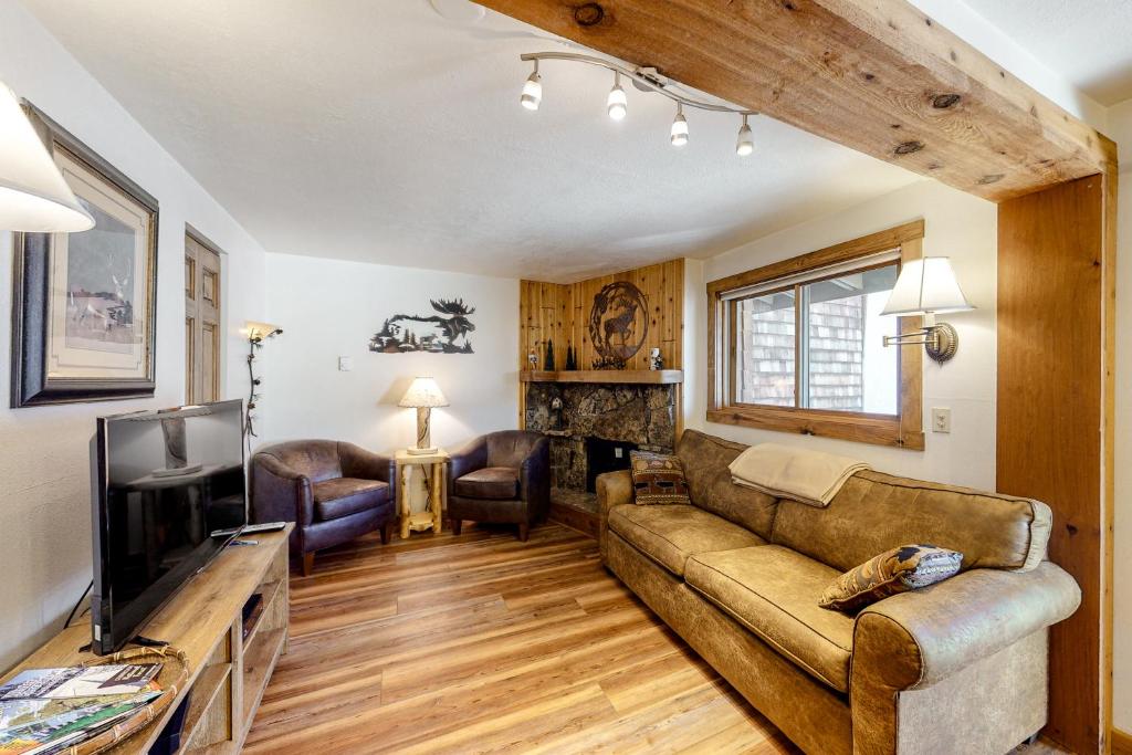 sala de estar con sofá y TV en Three Seasons Condominiums, en Crested Butte