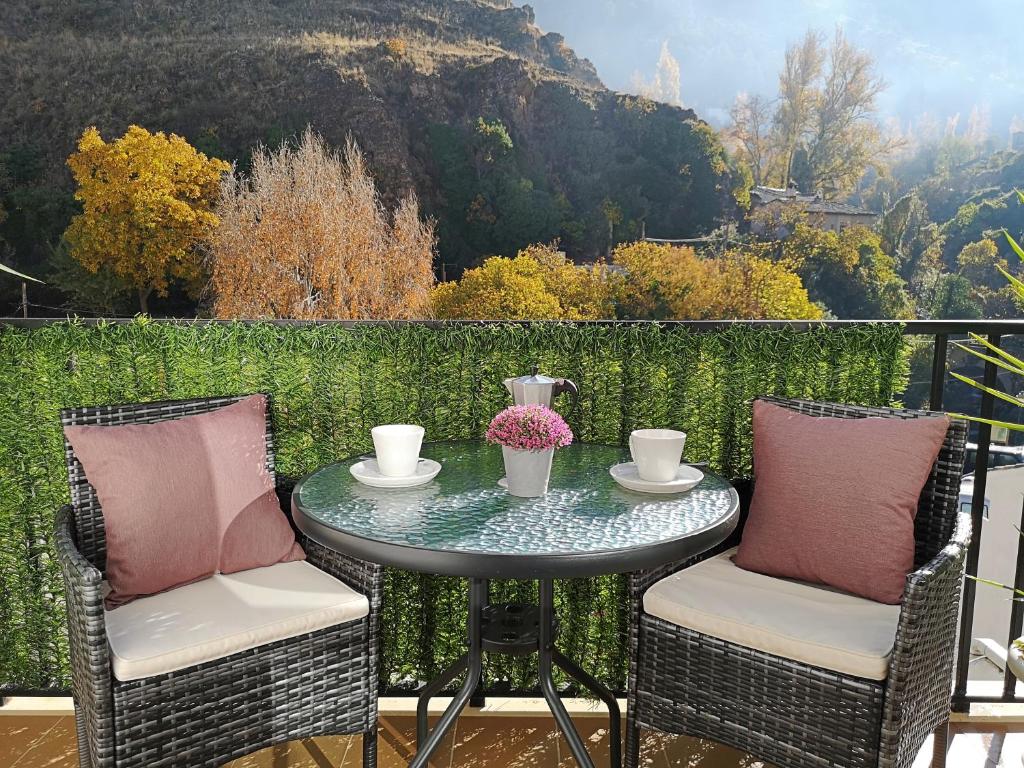 een tafel en stoelen op een balkon met een berg bij Salvatierra in Cazorla