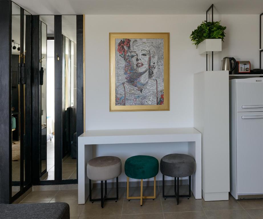 Sala de estar con 2 taburetes y una pintura en la pared en Brooklyn Apart By JlD Boutique en Villa María